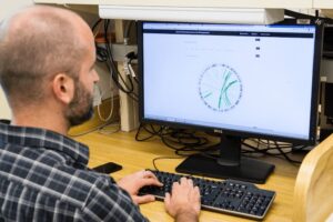 engineer sitting at computer working on mechanical drawing